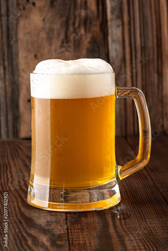 Glass of cold beer on wooden background