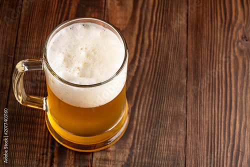 Glass of cold beer on wooden background