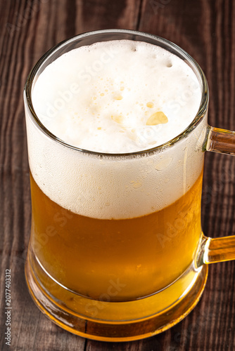 Glass of cold beer on wooden background
