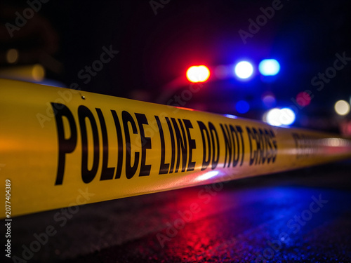 Police line tape with flashing lights at night
