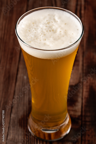 Glass of cold beer on wooden background