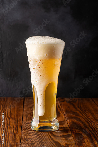 Glass of cold beer on wooden background