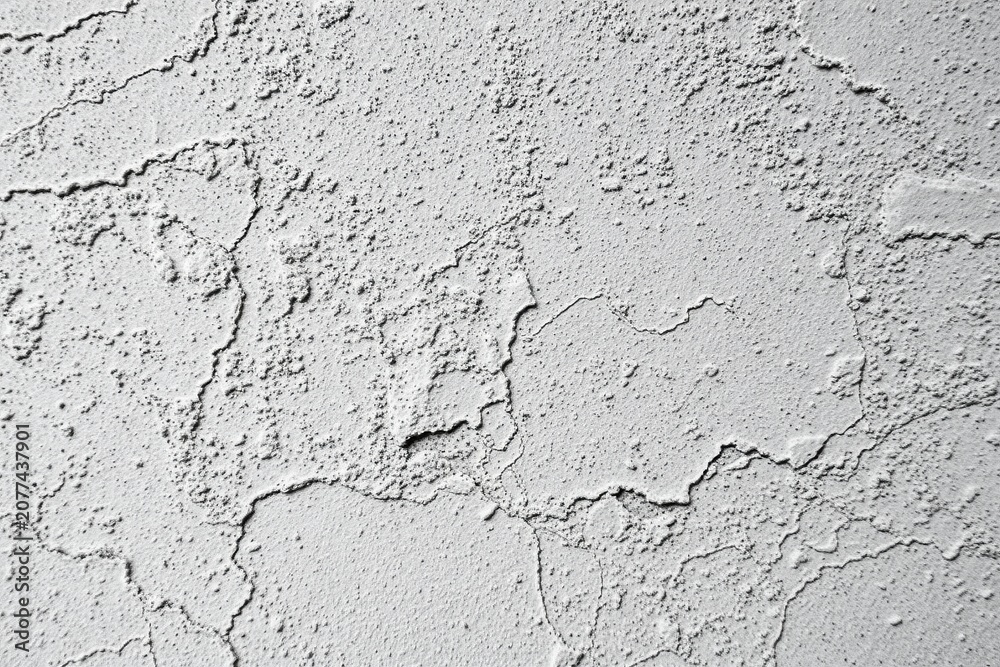 Fototapeta premium Rough texture covers surface. Gray tones dominate image, showing cracks, bumps, imperfections. Minimalist aesthetic.