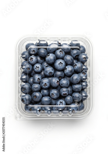 A top-down view of fresh, ripe blueberries packed neatly inside a clear plastic clamshell container, resting against a clean white background