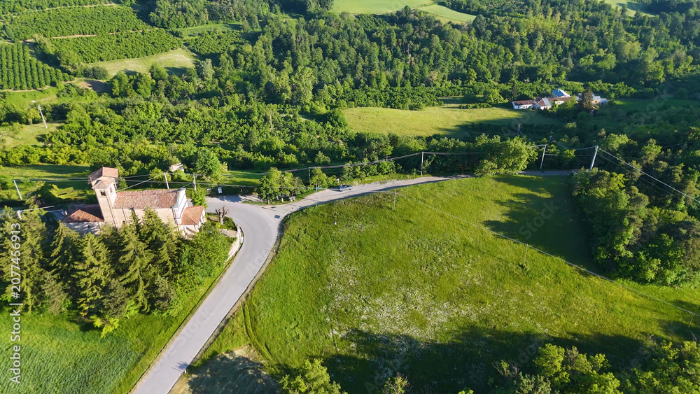 Fototapeta premium Aerial View of a Historic Church and Winding Road in Piedmont