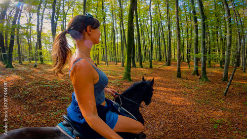 Obraz na plátně LENS FLARE, SELFIE: Woman enjoys a ride through green spring forest