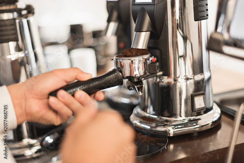 Foto グラインダーでコーヒー豆を挽くバリスタの手元