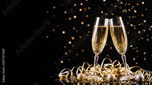Two champagne glasses toasting with gold confetti and ribbons