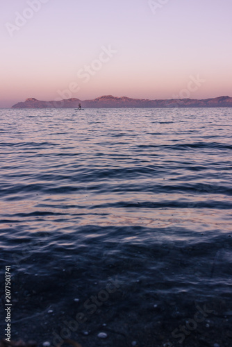 Tableau sur toile Calm sea in northern Mallorca at sunset with a lone person paddleboarding