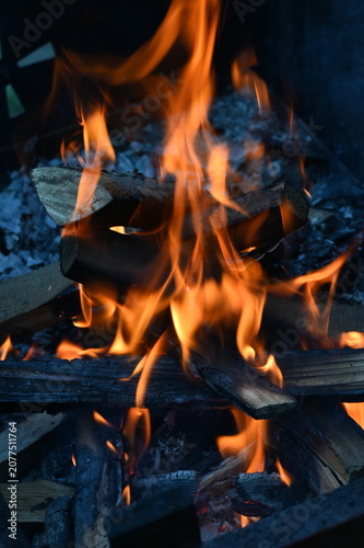 Warm fire burning in a traditional fireplace, glowing flames and natural wooden logs creating a cozy rustic atmosphere, warm home interior, peaceful winter evening