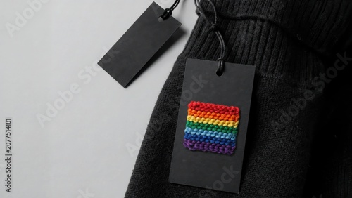 Black sweater with rainbow pride flag patch on tag, isolated on white background