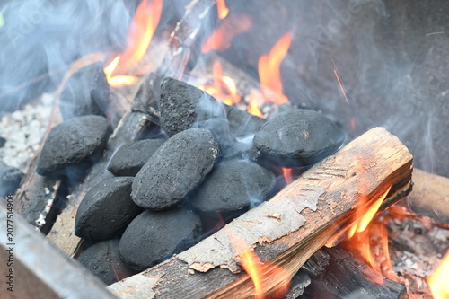 Fotografie Close-up of glowing barbecue briquettes with burning embers and soft smoke