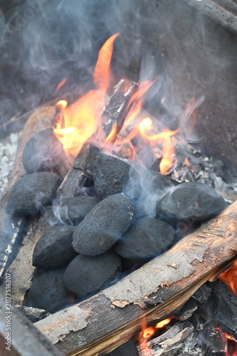 Fotografie Close-up of glowing barbecue briquettes with burning embers and soft smoke