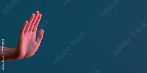 Human hand making stop gesture against dark blue background with copy space for professional communication and conceptual design projects