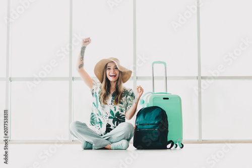 Tablou pe pânză Young woman excitedly anticipating her travel with suitcase and backpack in brig