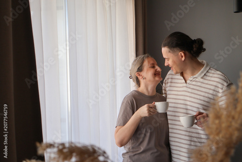 Valokuva Loving mid-age couple enjoying coffee by the window, sharing a quiet connection and peaceful domestic routine