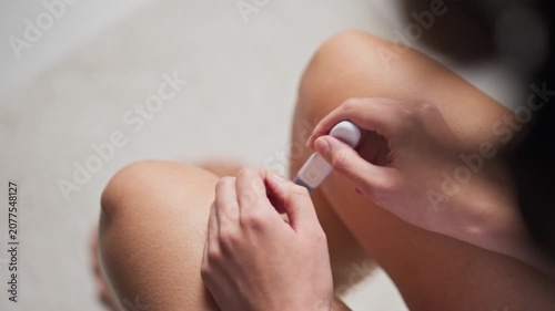 Woman holding a home pregnancy test showing a positive result. Concept of pregnancy confirmation, fertility, family planning, women's health, prenatal care, and reproductive healthcare.