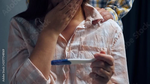 Woman holding a home pregnancy test showing a positive result. Concept of pregnancy confirmation, fertility, family planning, women's health, prenatal care, and reproductive healthcare.