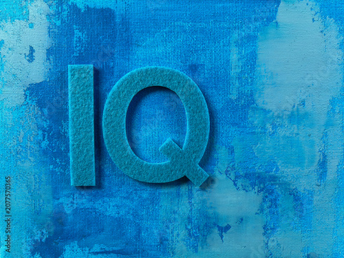 Konstfotografi IQ letters made from textured material on an abstract blue painted background with copy space, representing intelligence quotient, cognitive ability, education, psychology, learning, knowledge