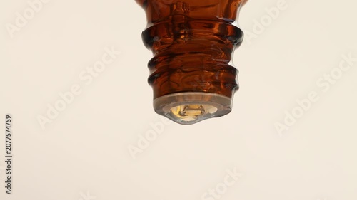 Close-up bottle with aromatherapy essential oil on beige background, front view.