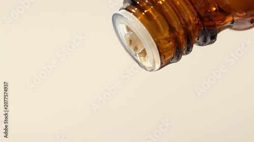 Essential oil for massage, cosmetic procedures, spa drips from a bottle, front view.