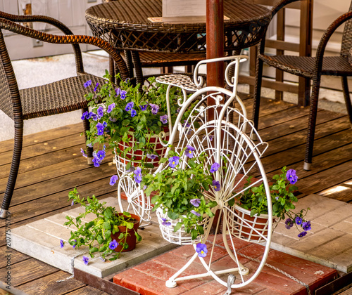 A table with chairs and flowers in a cafe.