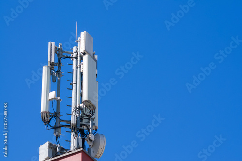 Cellular network 5g-4g antenna tower under blue sky in Lugano