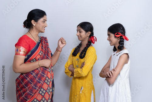 Konstfotografi A mother is in delight and feeling proud moments with both of her daughters as they are obeying her teachings, good manners feeling happy and proud showing a lovely mother-daughter bond