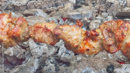 Shashlik with golden crust and spices grills on a skewer over hot coals