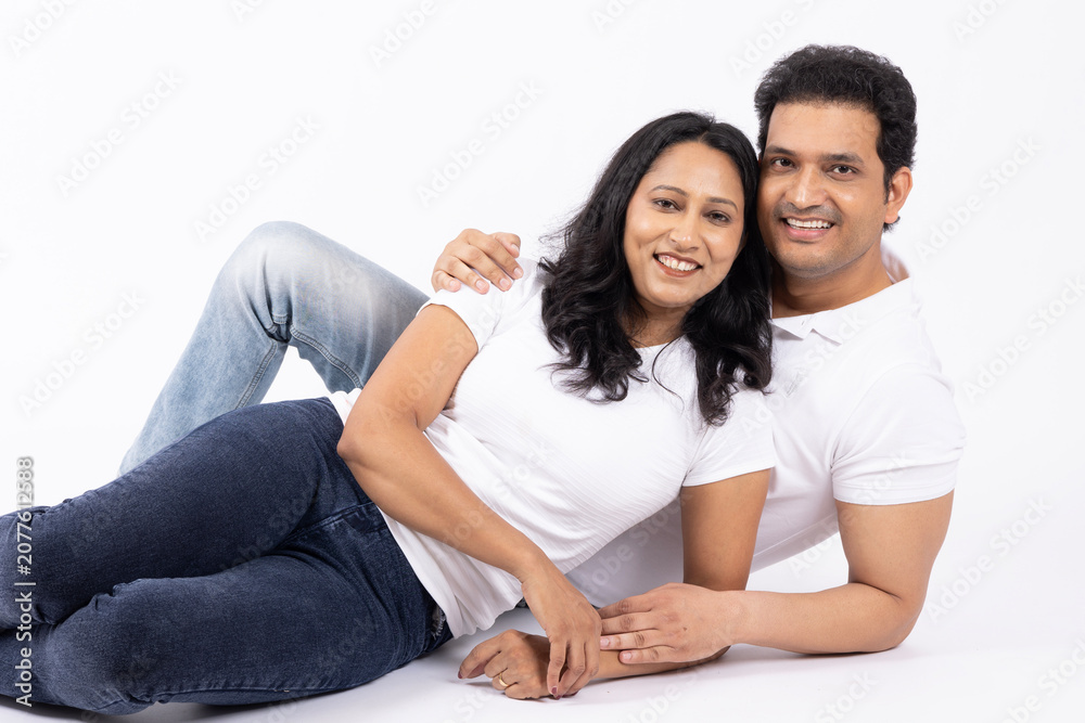 Fototapeta premium Indian happy beautiful family. Indian happy family of a father, mother and daughter standing together on a white background.