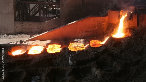 Fotografie Molten ferroalloy metal being tapped from a submerged arc furnace into molds during pyrometallurgical smelting of ore