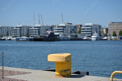 Foto Yellow mooring post and the city in the background