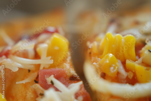 Close up of freshly baked cheesy pizza with sweet corn kernels.
