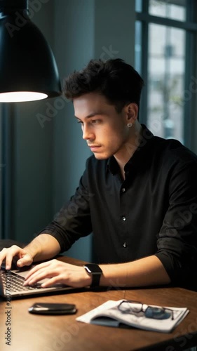 Young businessman in office working on computer fashion editorial shot, high-fashion imagery, avant-garde aesthetics, editorial storytelling, conveying fashion trends and concepts, ar.
