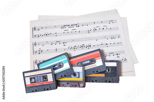 audio cassettes and music sheets isolated on white