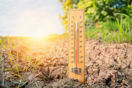 Heatwave in summer, thermometer on sunny hot day, weather forecast in summertime, measure the temperature, dry soil