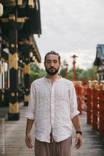 portrait of a man meditating standing on the street japan chinese background