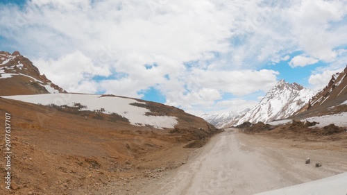 4K POV shot of a vehicle driving on a dirt road while crossing the Lachulung La on Leh Manali highway between Sarchu and Pang in Ladakh, India. Scenic view of Himalayan high mountain pass crossing.