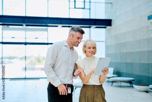 Foto Two smiling businesspeople, a man and a woman, collaborating and discussing work