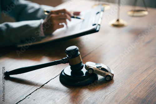 Fotografie Judge's gavel and model car on a desk, representing vehicle auctions, legal disputes, insurance claims, and automotive law