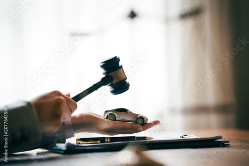 Fotografie Judge's gavel above a model car, symbolizing vehicle auctions, legal disputes, insurance claims, and automotive law