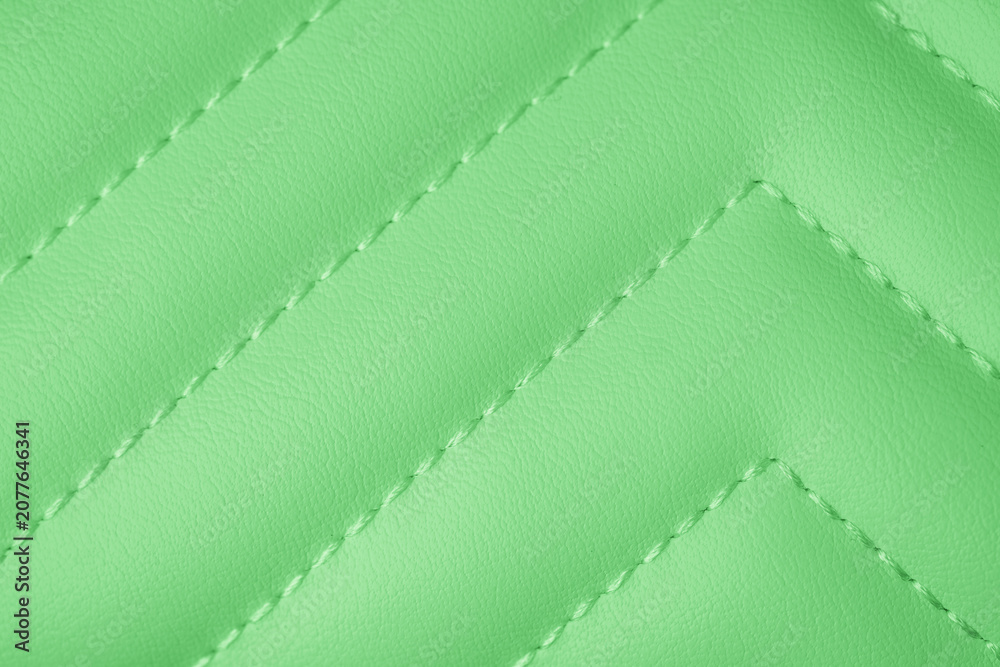 Fototapeta premium Vibrant lime green smooth textured padded fabric with intricate chevron quilted pattern close up surface