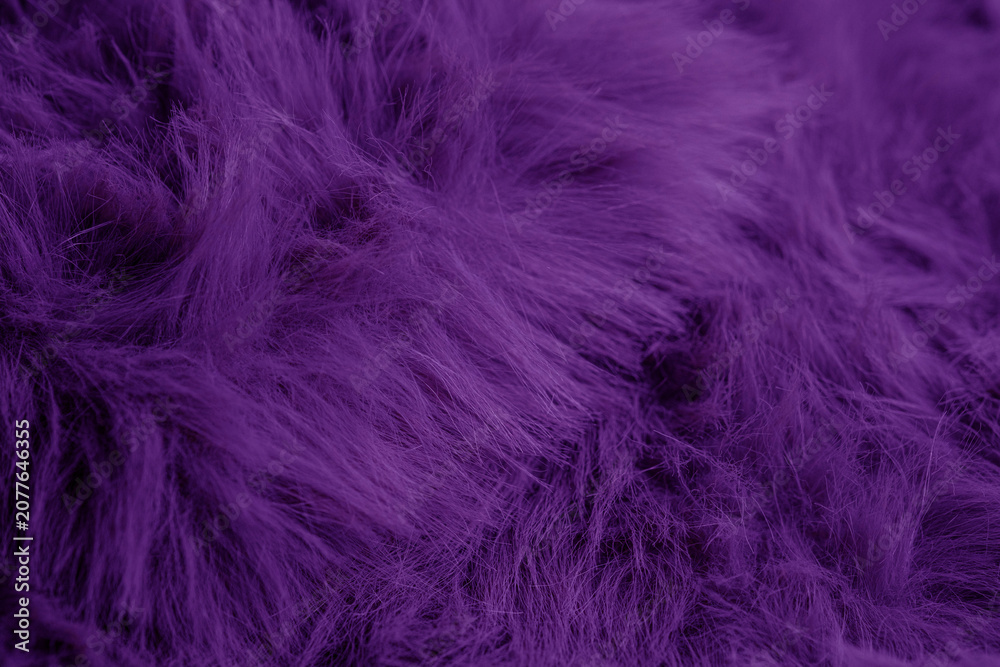 Fototapeta premium Deep vibrant purple fluffy faux fur textile material background with soft wavy pattern and texture