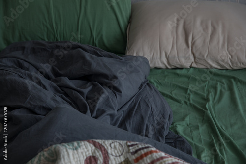Fotografie A bed with black, green, and beige bedding
