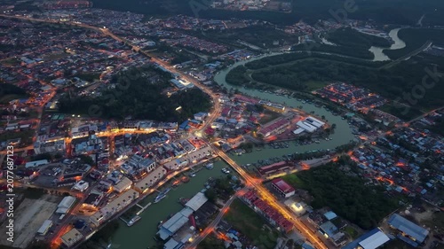Aerial city view glows at dusk along a river