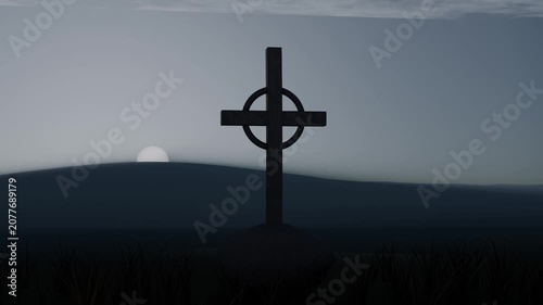 Rising sun illuminating ringed cross silhouette on low hill at dawn, bringing pale light