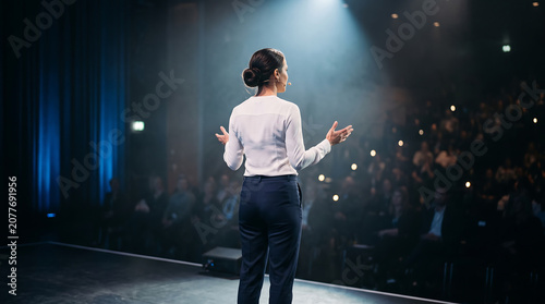 Female speaker presenting on stage at business conference