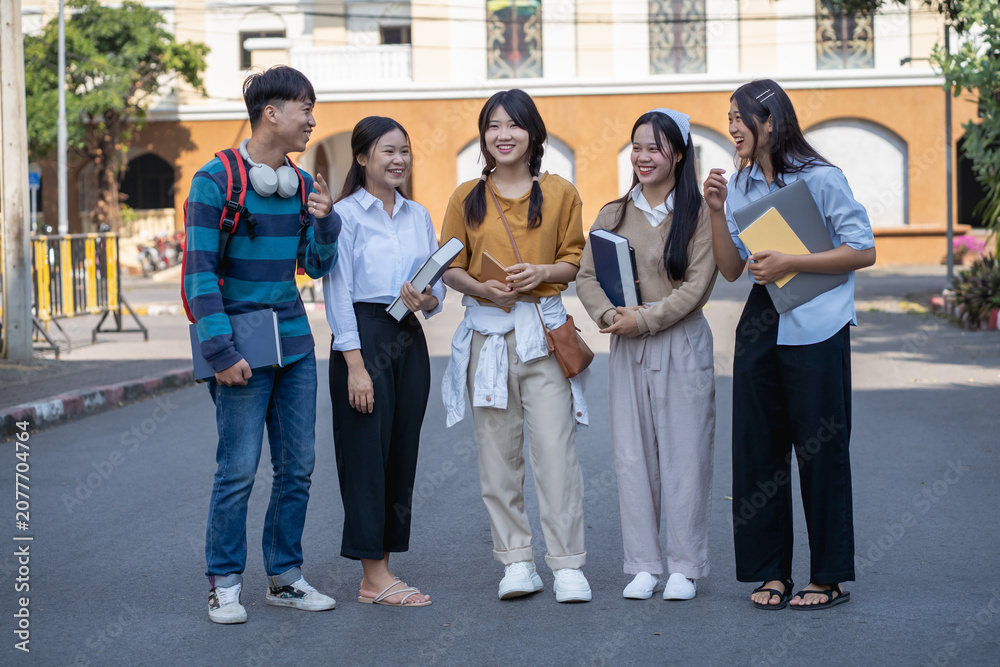 Fototapeta premium Diverse group of young students enjoying a vibrant conversation in an outdoor urban environment