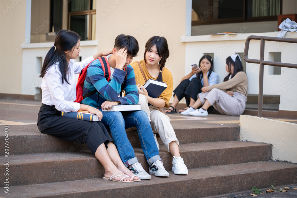 Fototapeta premium A diverse group of students actively discussing ideas while sitting on the steps of their campus outdoors