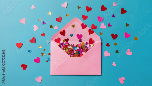 Pink Envelope with Exploding Heart Confetti on Blue Background